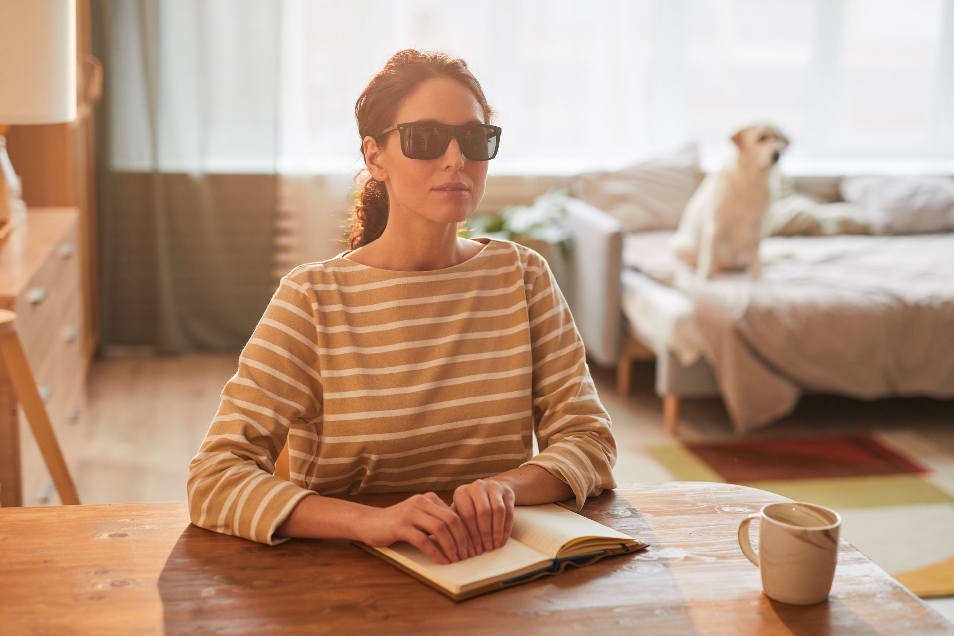 una donna legge in braille sottolineando l'importanza dell'accessibilità sensoriale, che sia per le persone cieche o sorde